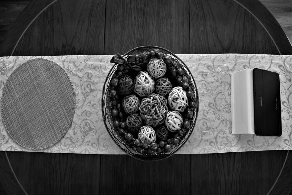 Woven linen placemats arranged on rustic wooden table with fresh flowers
