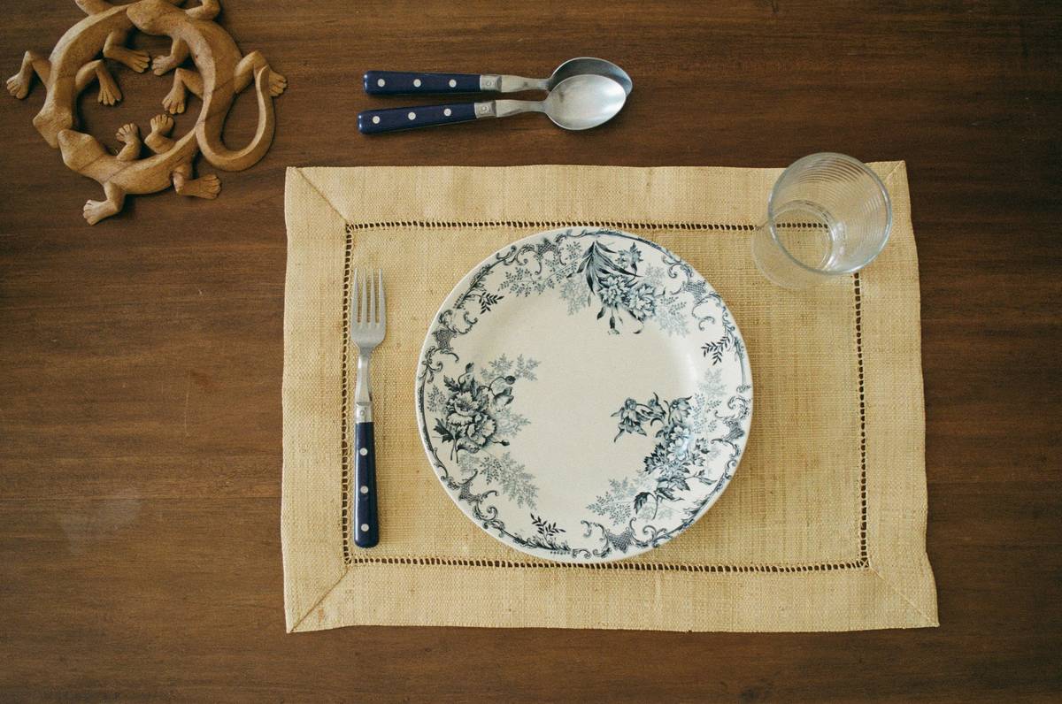 home table decoration placemat on rustic wooden dining table with ceramic dishes and linen napkins